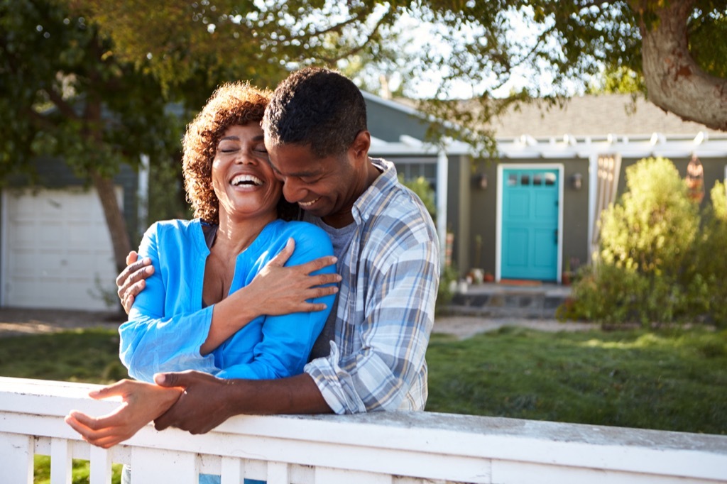 couple outdoors by house laughing, better wife after 40