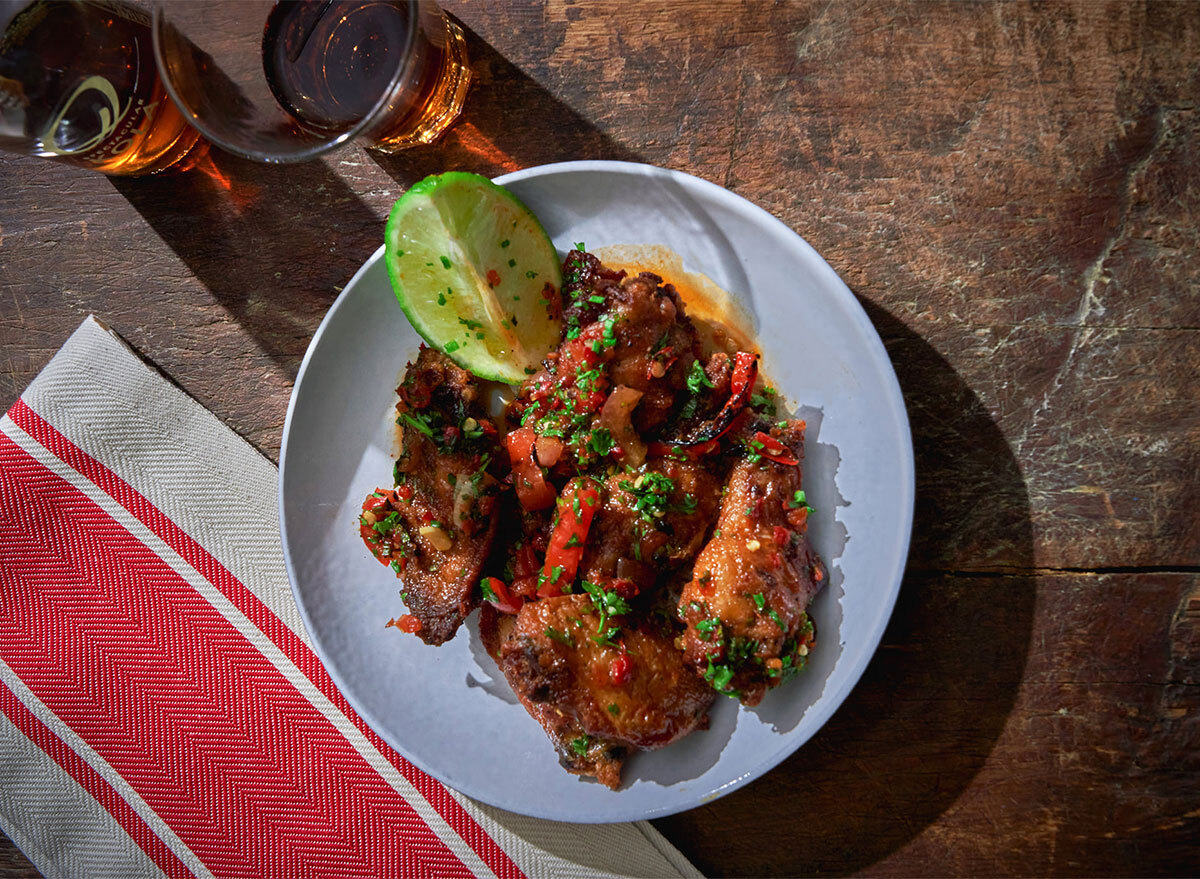 plate of chicken wings with lime wedge