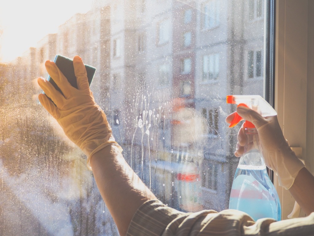 person cleaning a glass window