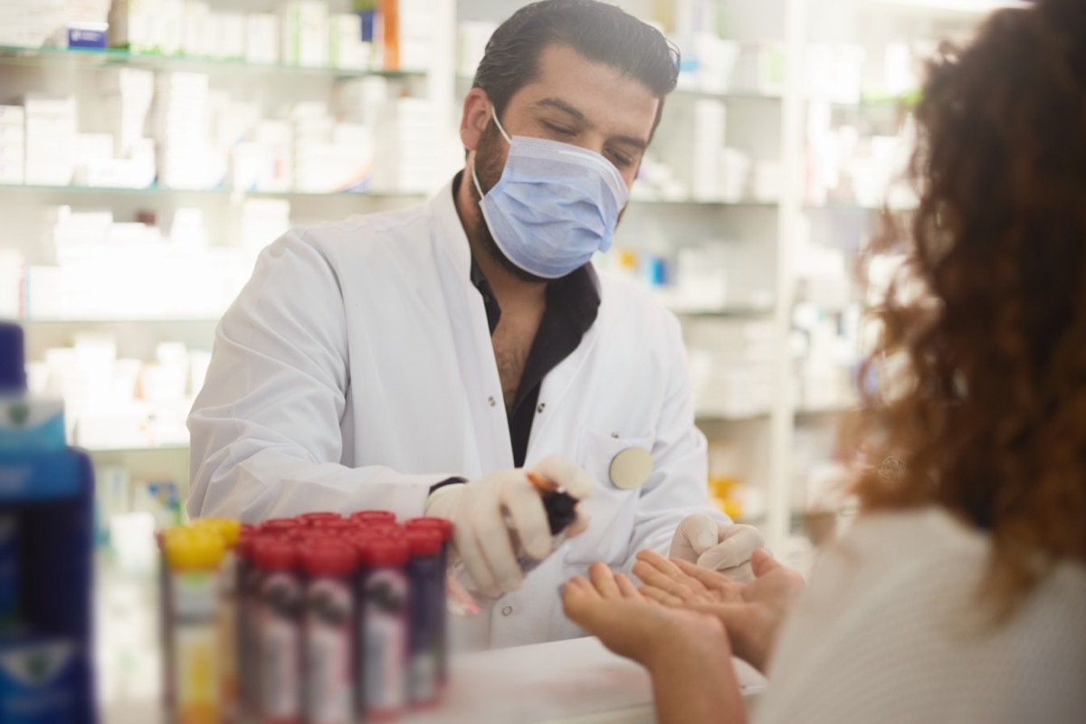 pharmacist squeezes hand sanitizer to the customer