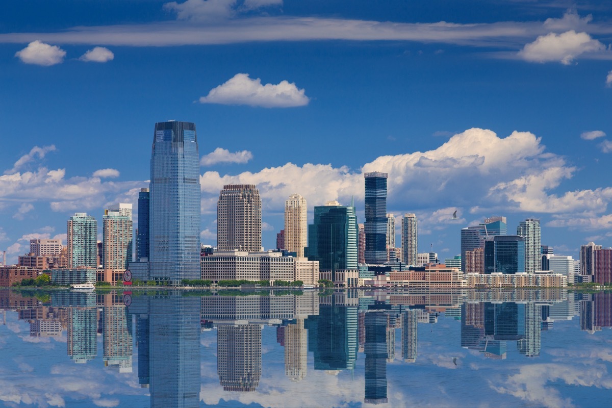 Jersey City Skyline with Goldman Sachs Tower Reflected in Water of Hudson River, as seen from Battery Park, Lower Manhattan, NY, USA. The image lit by the morning sun. Canon EOS 6D DSLR and Canon EF 24-105mm