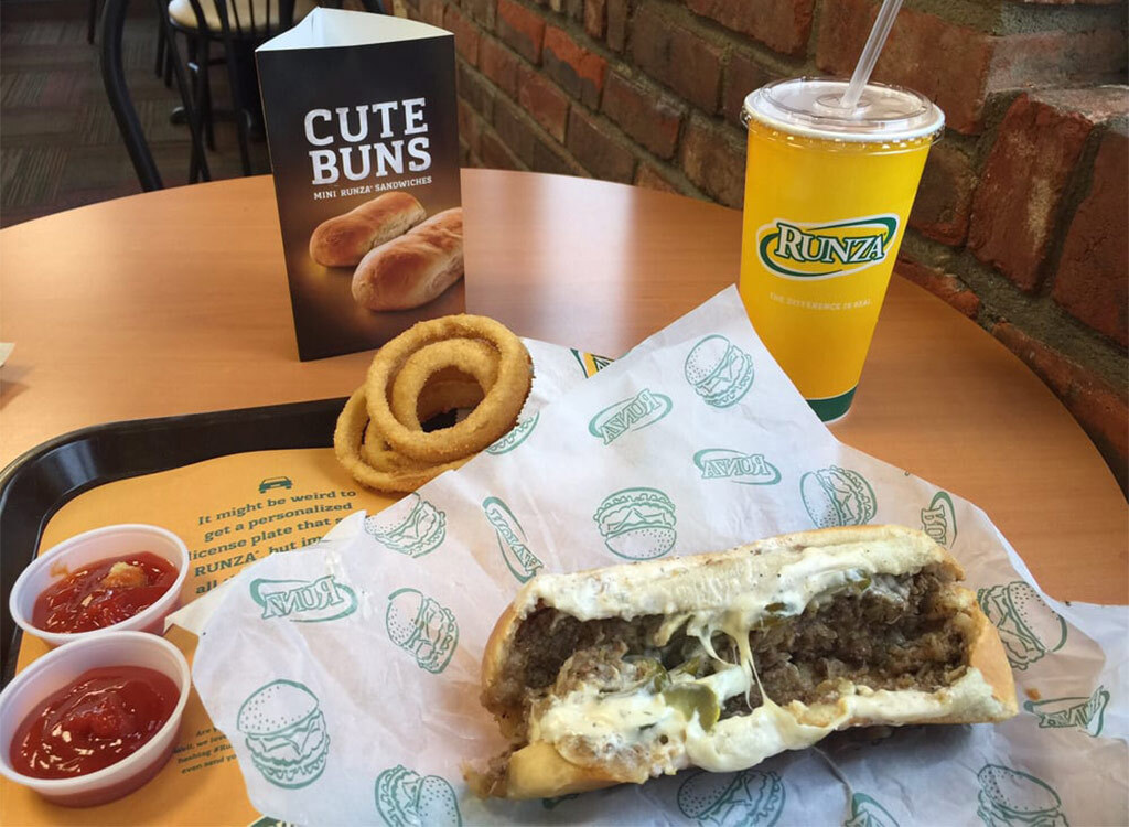 Runza sandwich on fast food tray with ketchup onion rings and soda