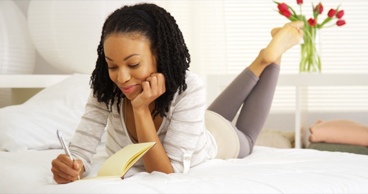 Young Black woman writing in journal