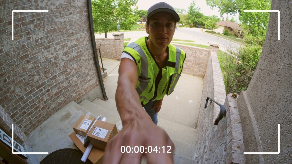 Packages being delivered to a home, as seen from a security camera.