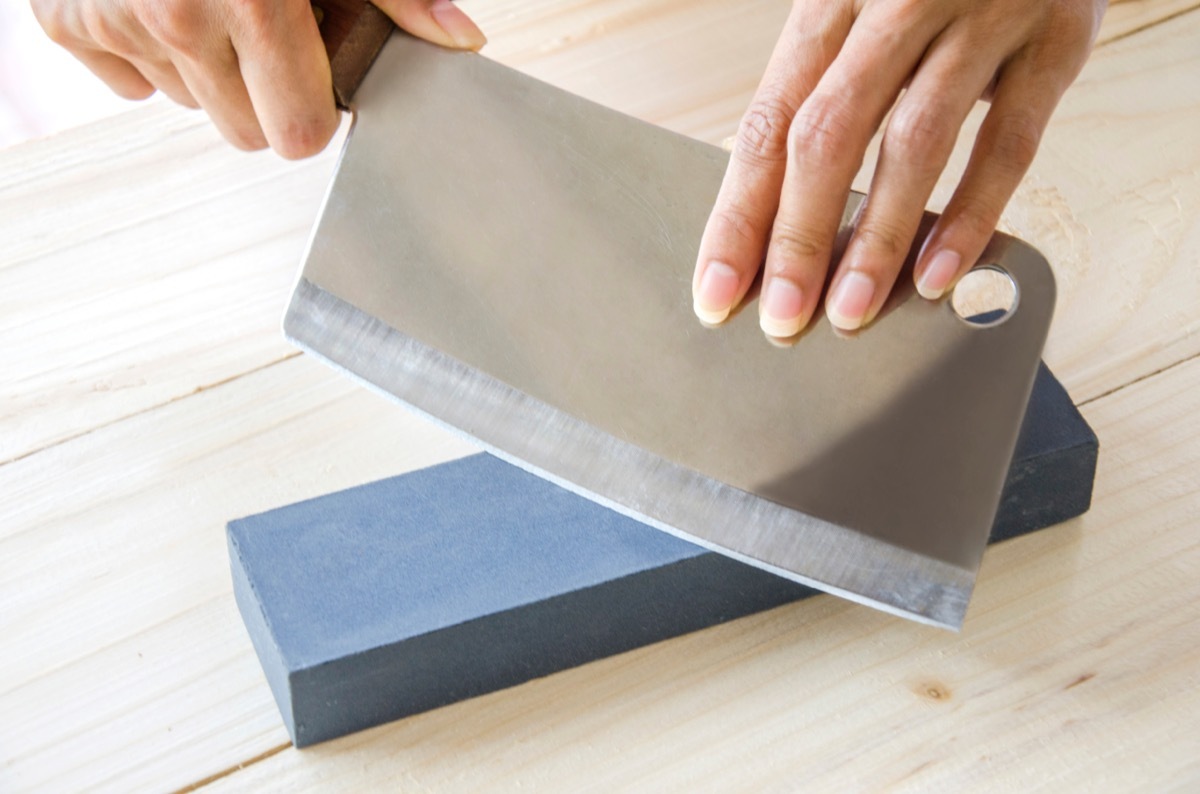 Person sharpening a knife cleaver