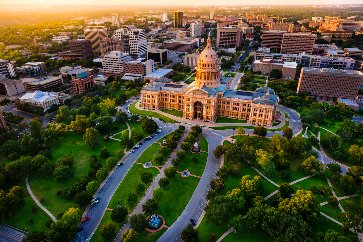 The skyline of Austin, Texas at sunset with the State Capital building in the foreground