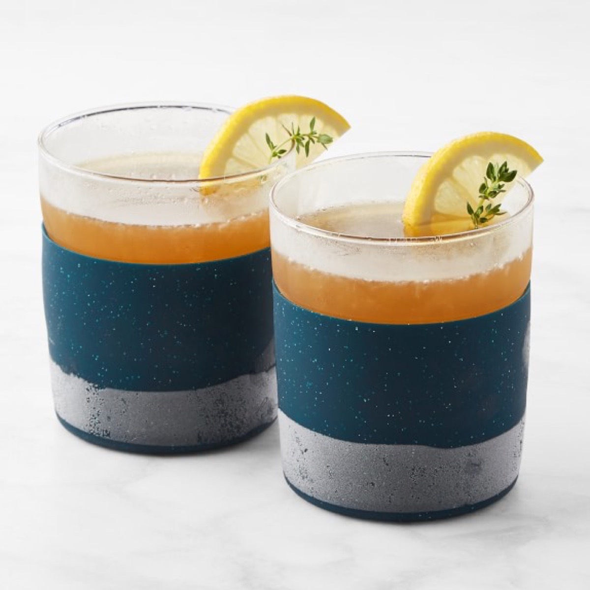 set of two colorblocked tumblers with drinks in them and lemon wedges on the edge