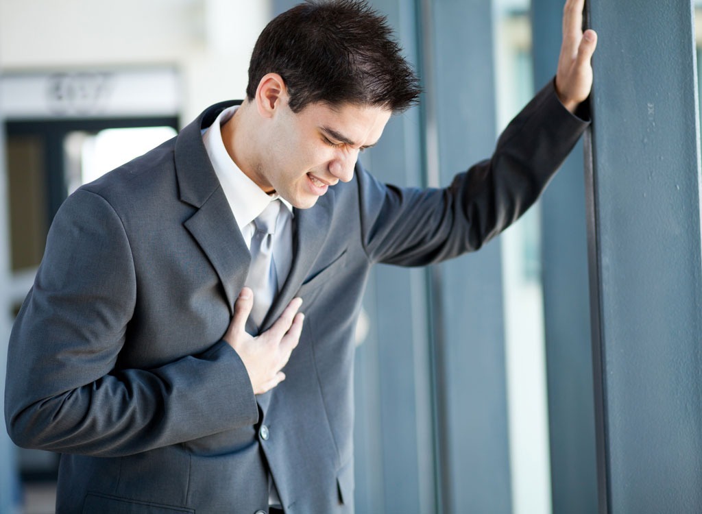 man in suit holding chest