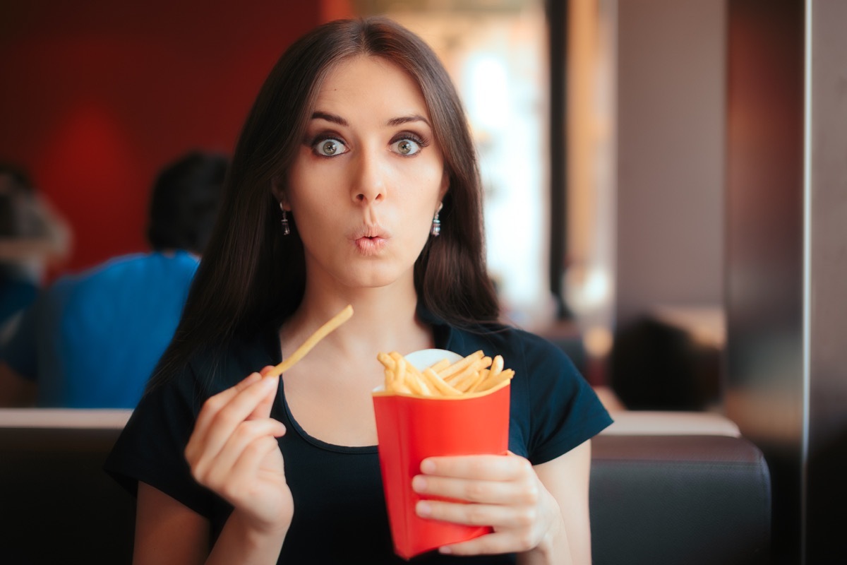 Woman eating salty french fries