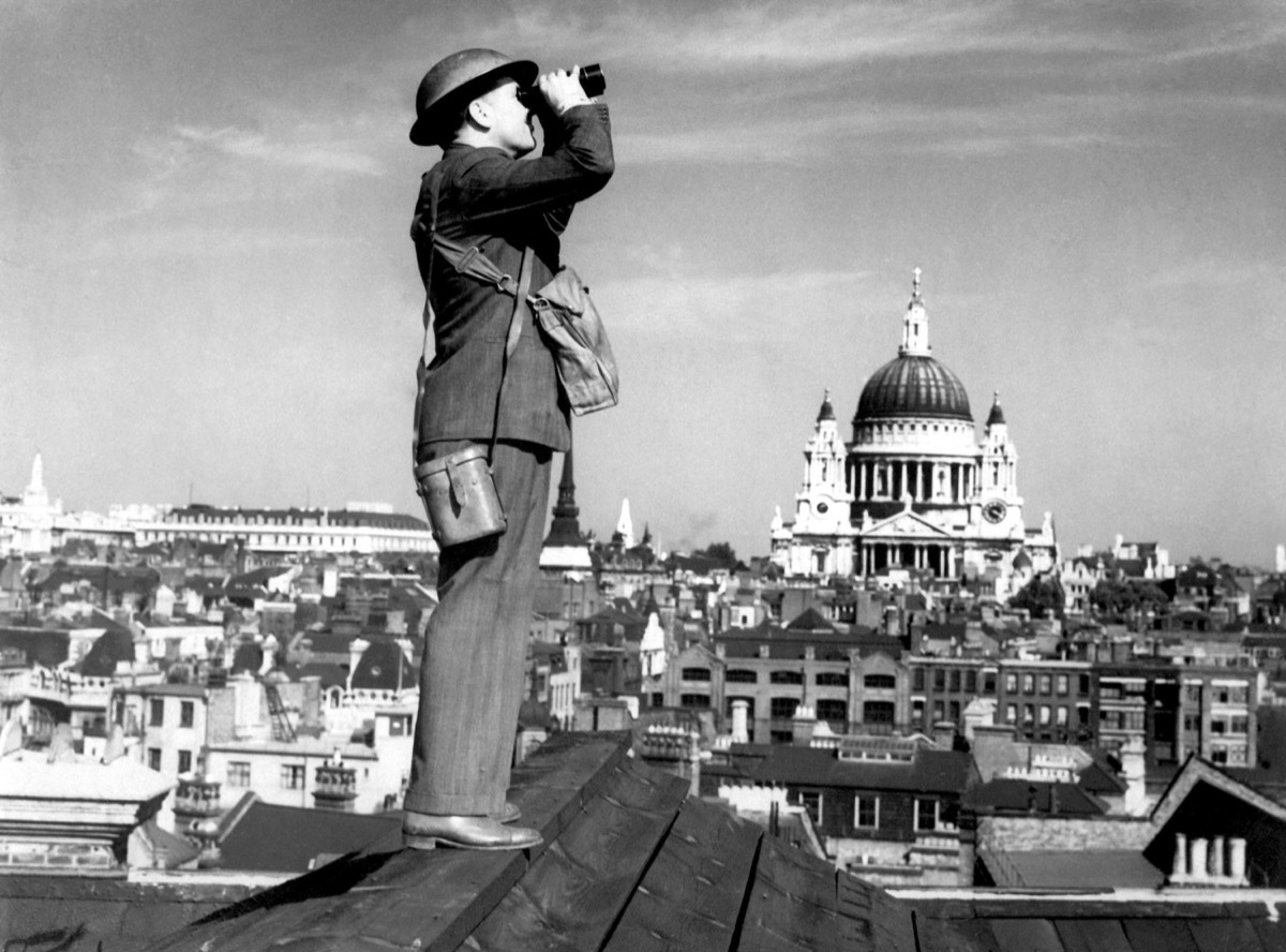 Aircraft spotter searches the sky with binoculars during the Battle of Britain. St. Paul's Cathedral is in the background. World War 2