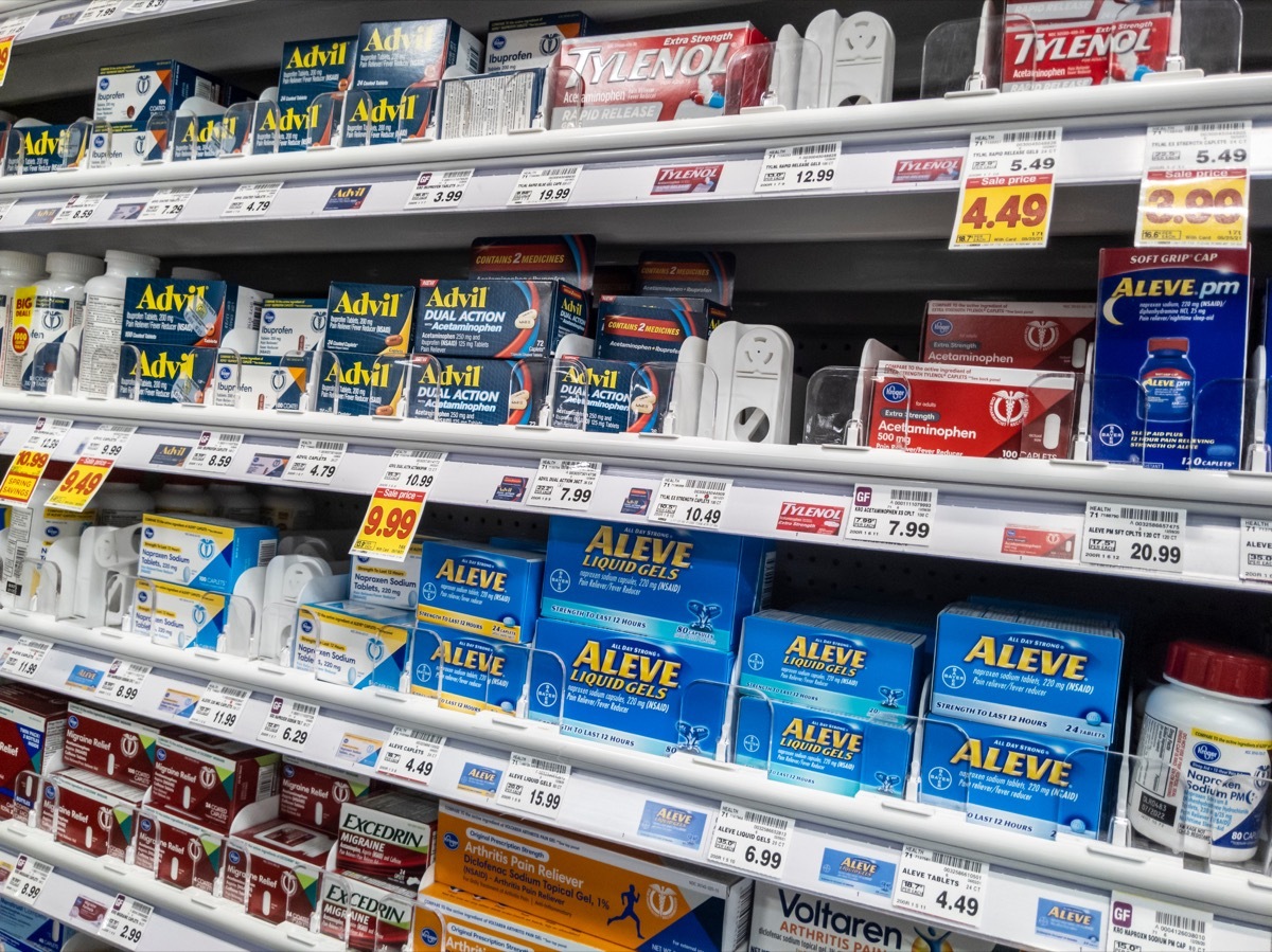 Angled view of a pain reliever display in the pharmacy area of a QFC grocery store.