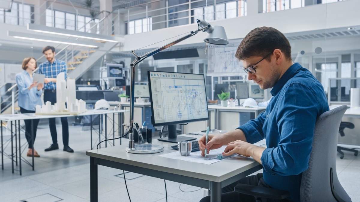 architect working at his desk with his office space in the background