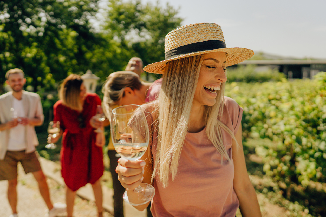 Photo of a couple of friends having a good time in a winery, tasting and trying different types of wines