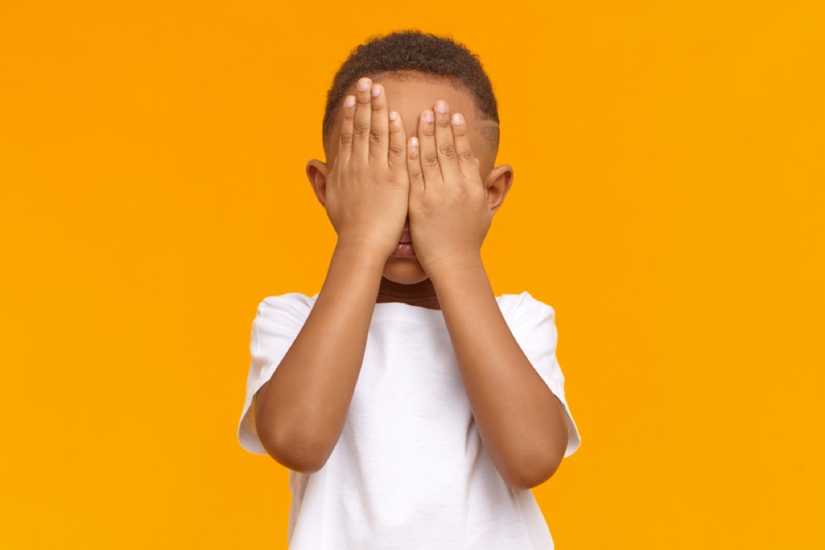 little boy covering face with hands, parenting myths