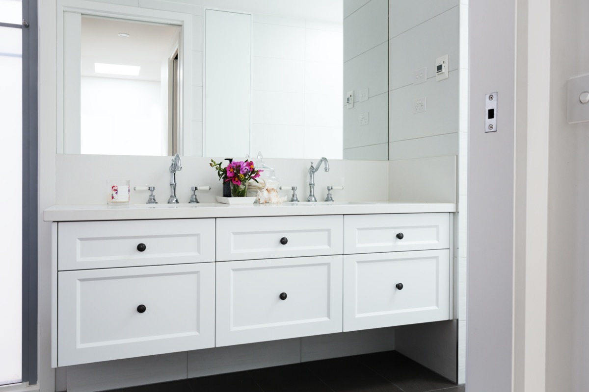 white bathroom vanity with round black knobs