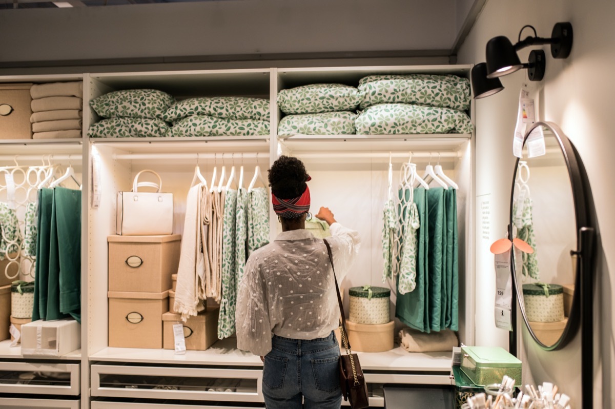 African-American woman from behind as she looks at colorful and organized displays at a furniture store