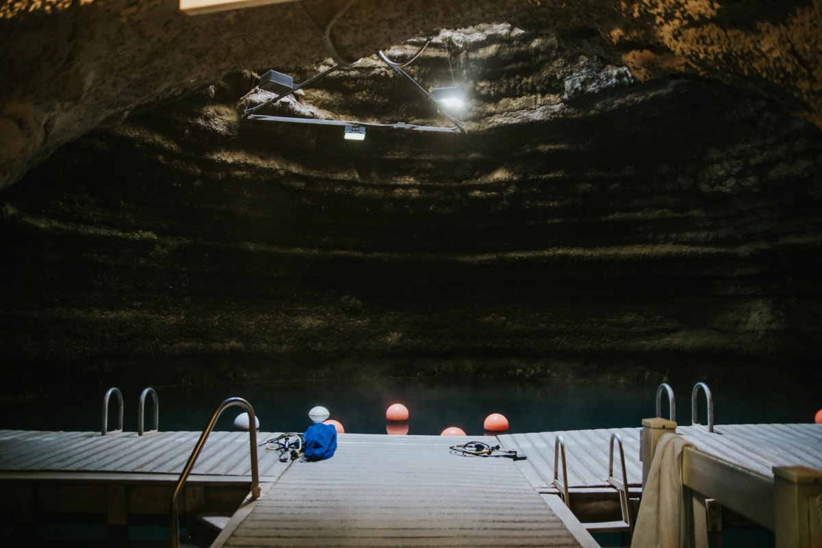 sun comes through a crater opening into a pool below