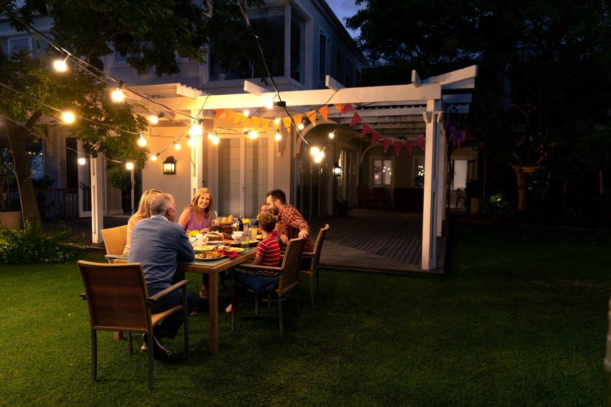 family sitting at dinner in backyard