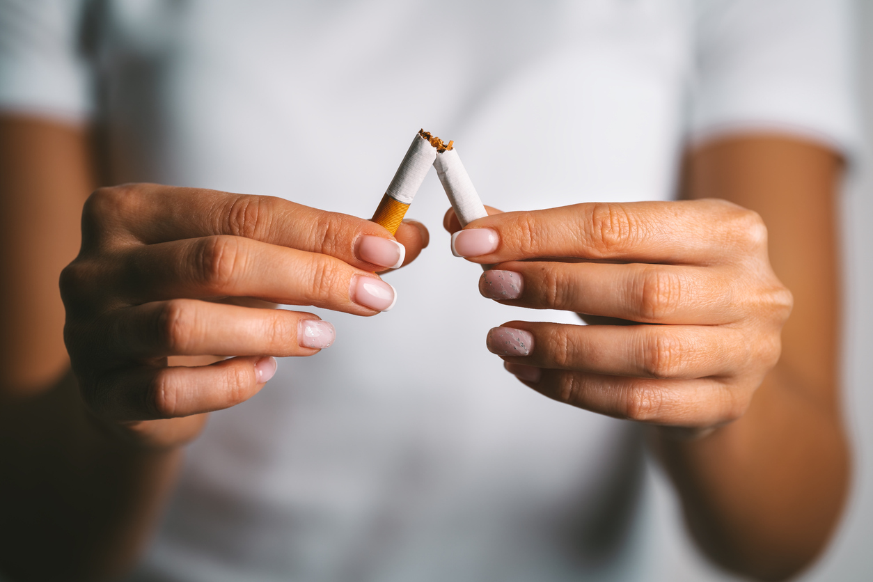 Women breaking a cigarette in half.