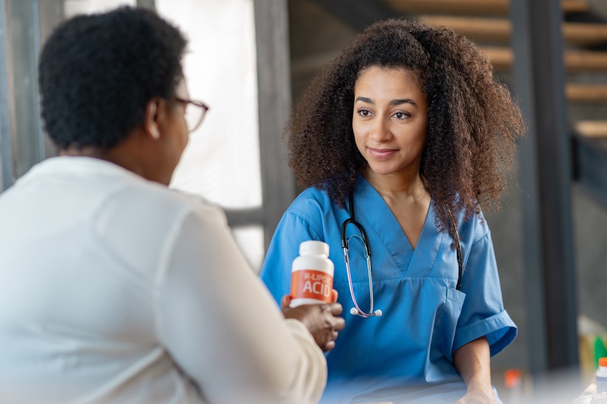 dark-haired nurse listening to pleasant aged woman in the hospital