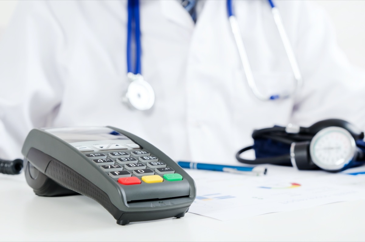 POS terminal in doctor's office. Pay for private health care concept.