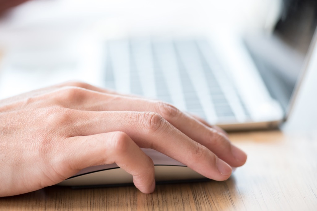 Man clicking on a mouse by the computer.