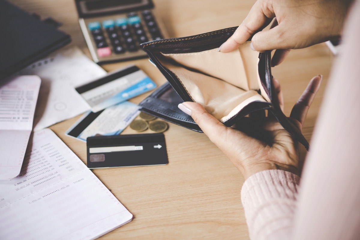 woman emptying wallet onto desk