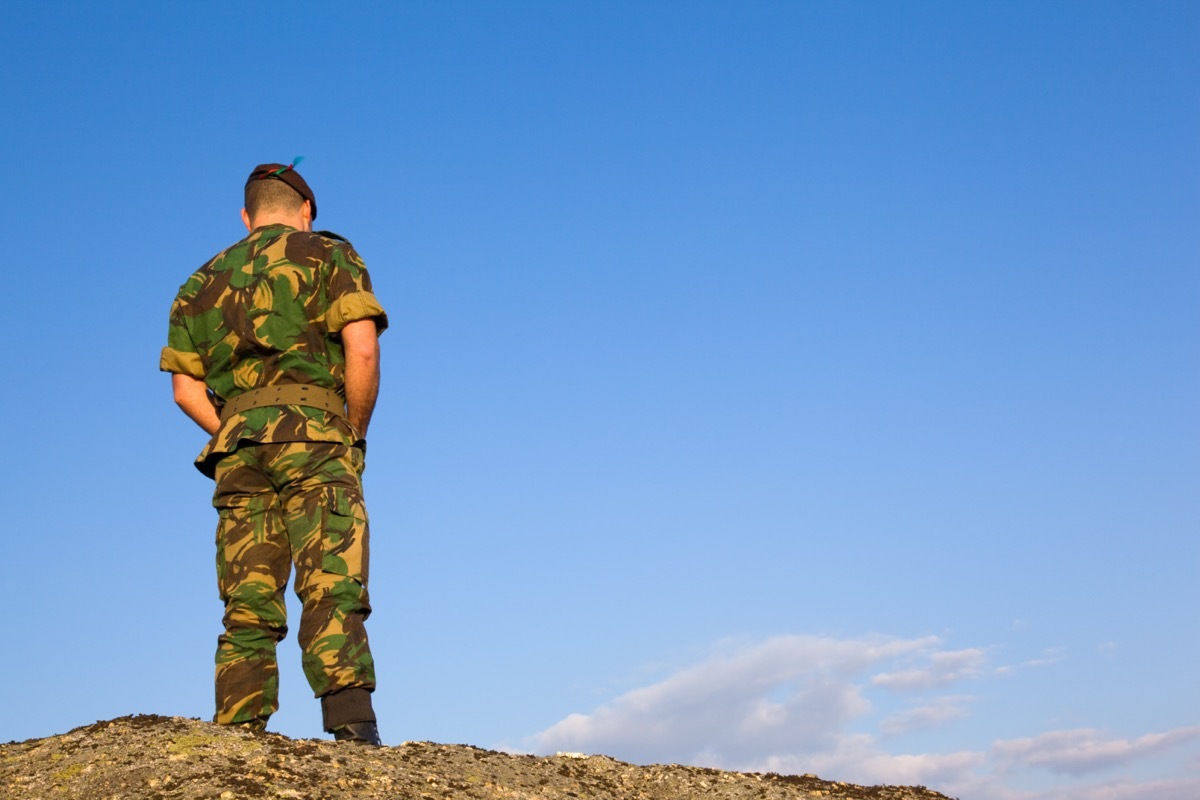 the back of a military man standing and looking down