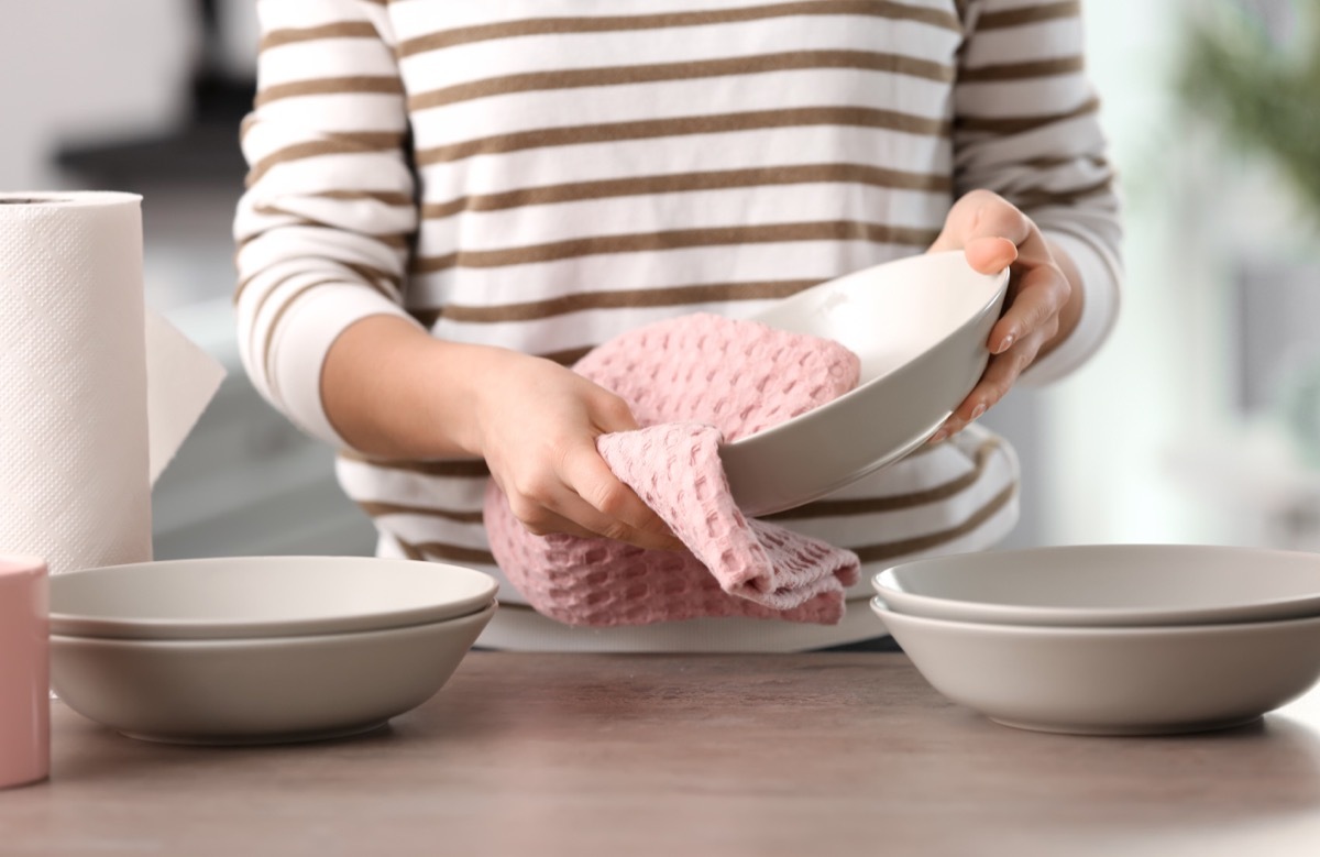 Woman drying dish with towel