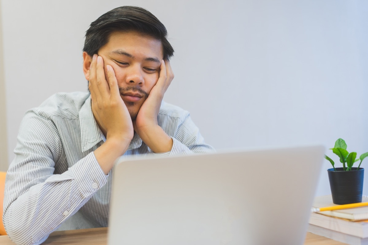 Man is Sitting by His Computer Bored at Work ways we're unhealthy