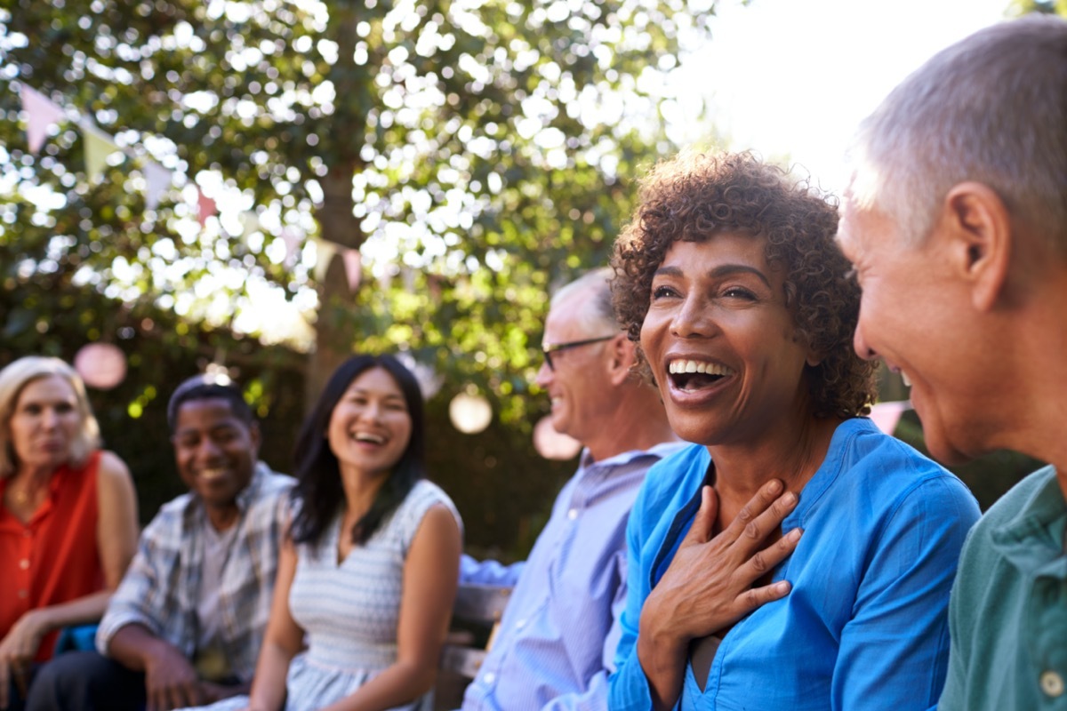 Mature friends laughingat backyard party