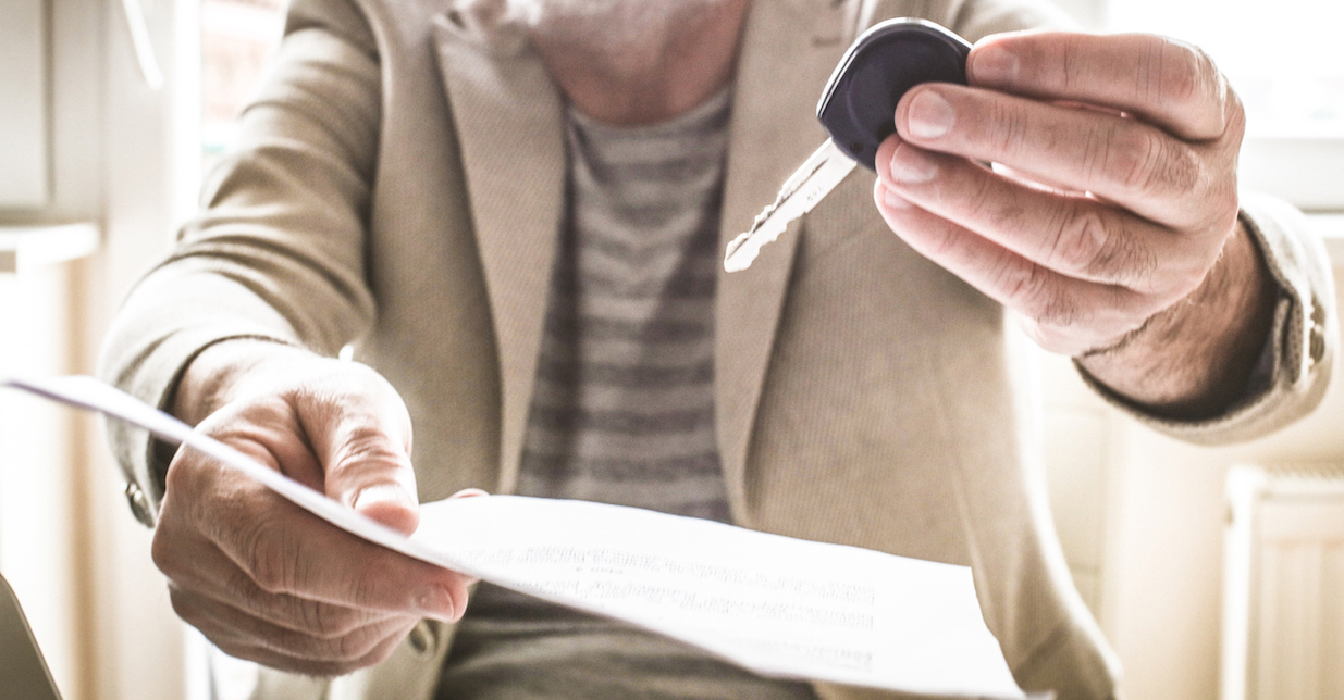 Close up of man's hand giving car key.