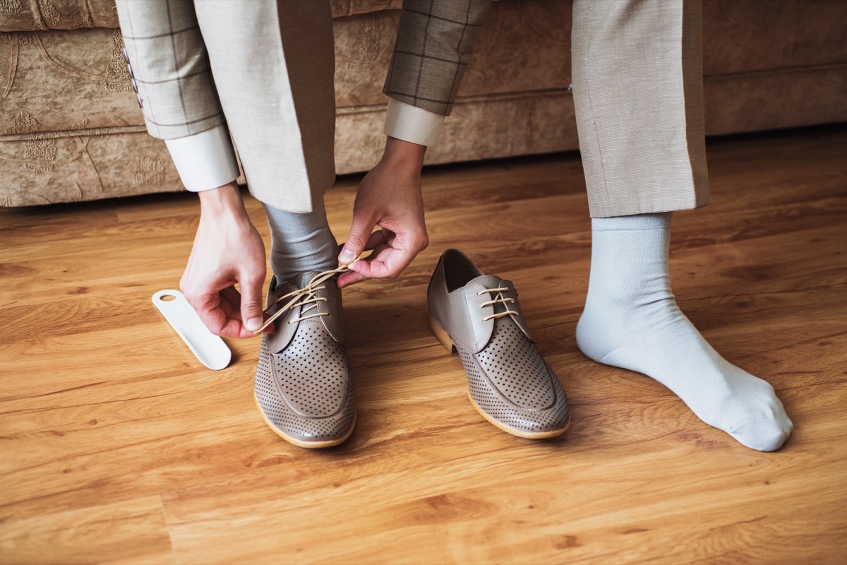 Man putting on socks and dress shoes