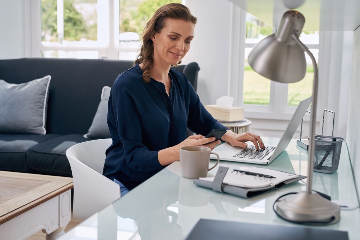 middle aged white woman working at desk in home office working from home