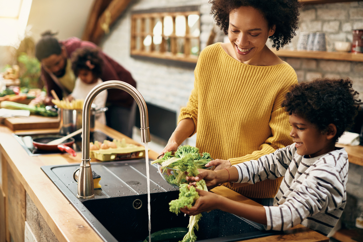 A family washing vegetables while preparing a meal