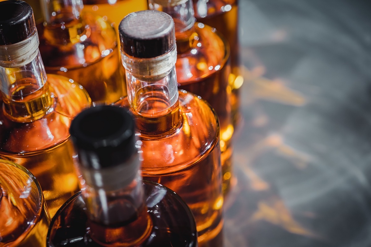 Small liquor production based on maple syrup. Multitude of pure alcohol bottles not labeled. Bottles placed in a row.