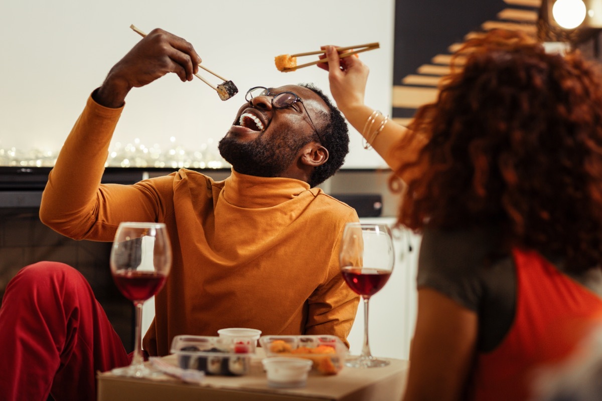 couple eating sushi together at home