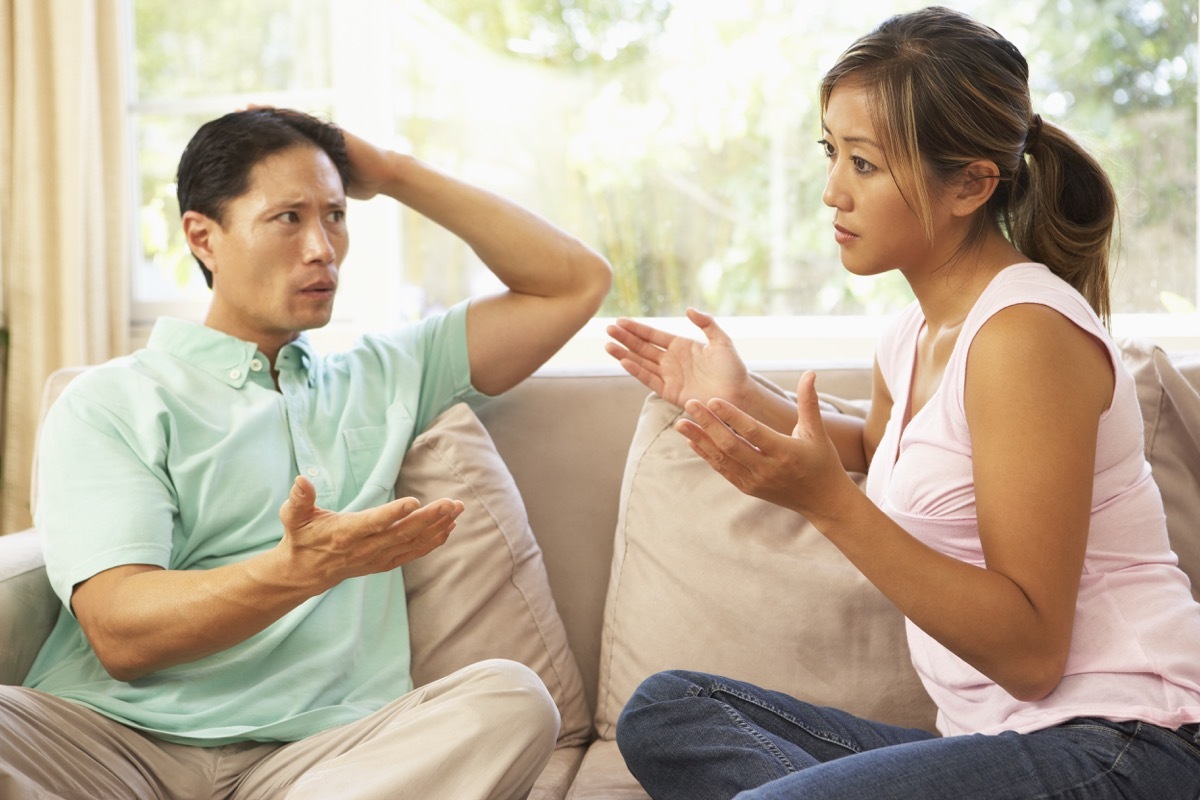 30-something asian couple arguing on couch