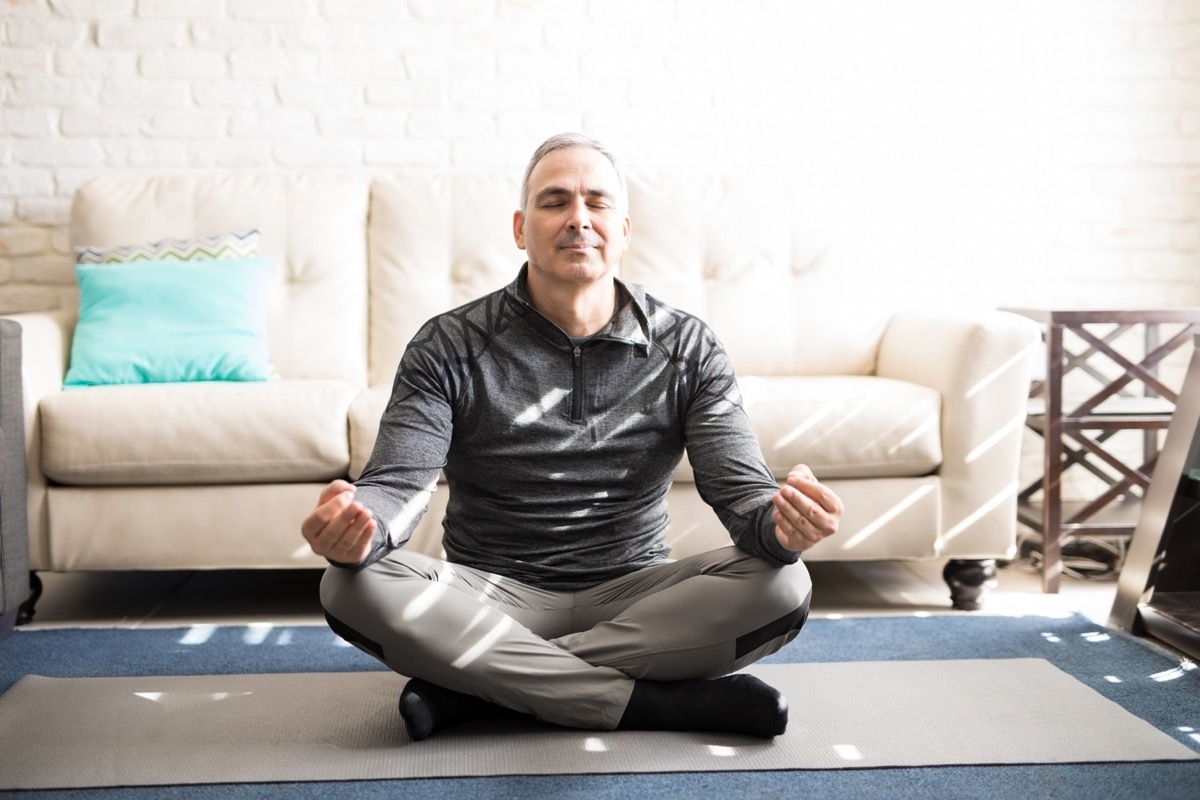 Man meditating in living room