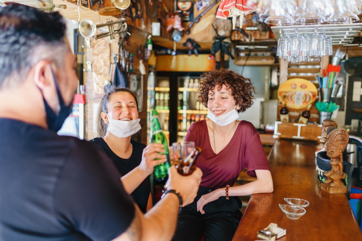 People cheering with beer in bar.