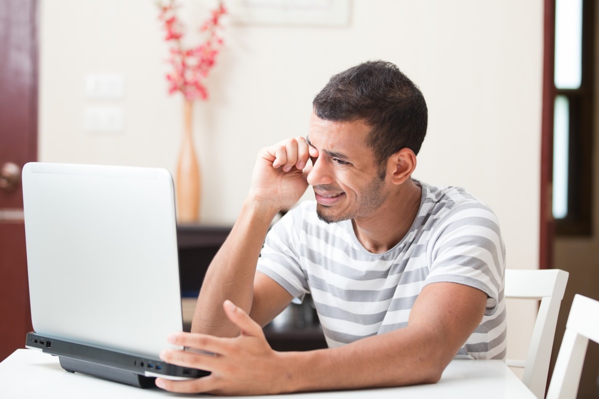 Man with blurry vision squinting at his computer screen