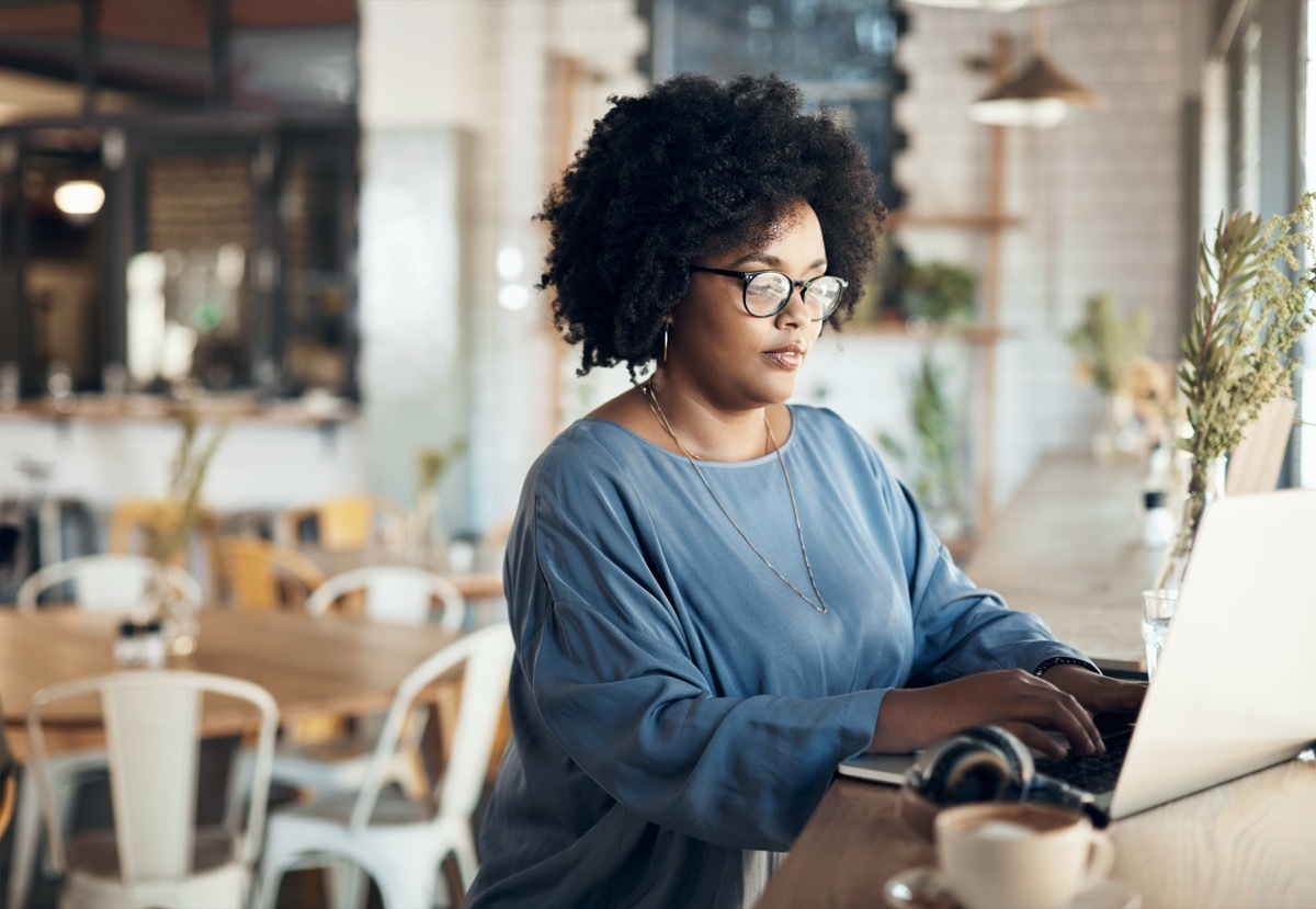 Cropped shot of an attractive young businesswoman sitting alone and working on her laptop in a cafe