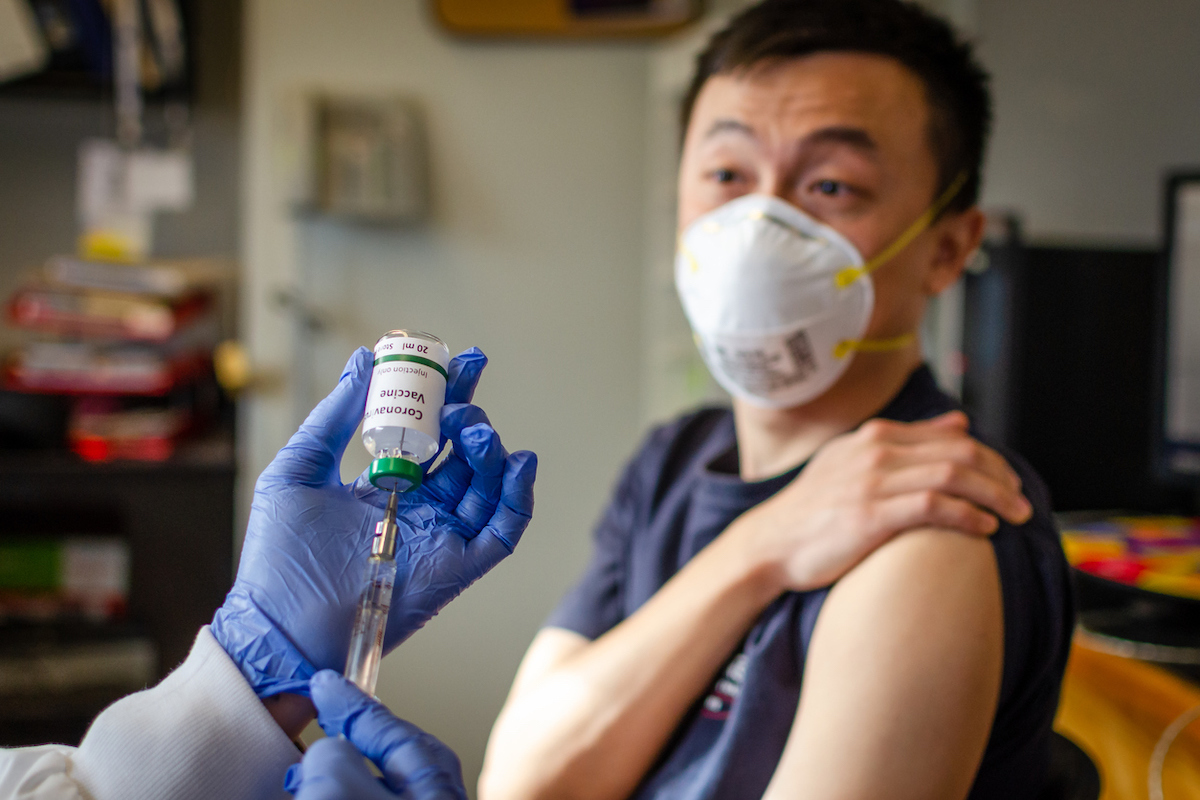 Asian male getting vaccinated against coronavirus