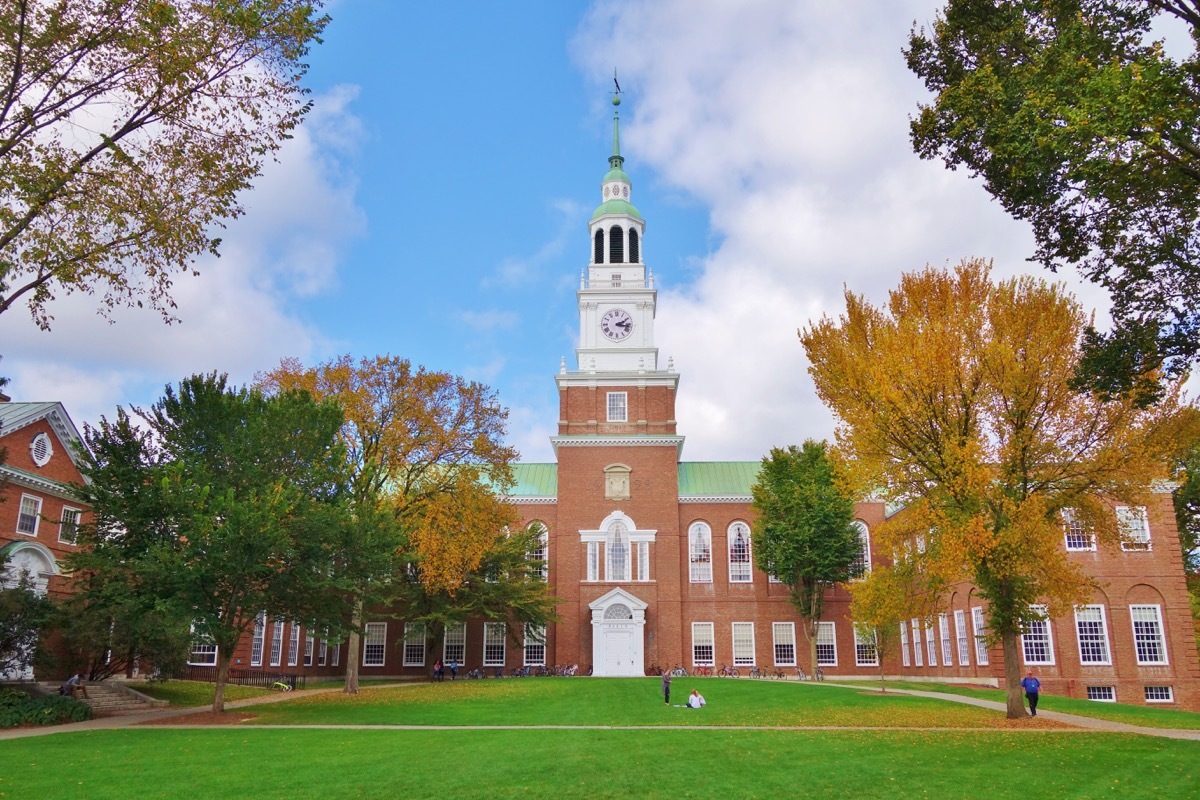 Looking down the Dartmouth Green with trees beginning to show fall colors and a blue sky with puffy white clouds on a nice autumn day the Baker Library and its bell tower is in the background. - Image