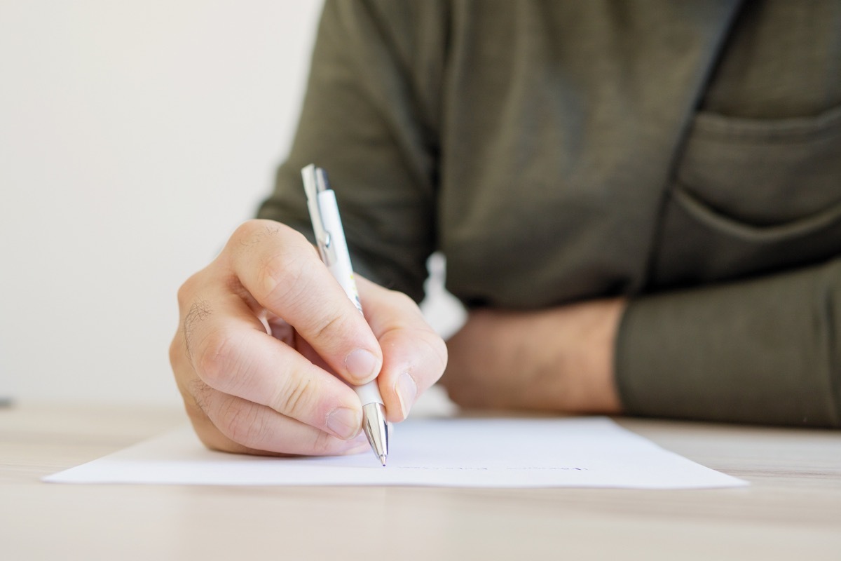 man writing a letter with a pen