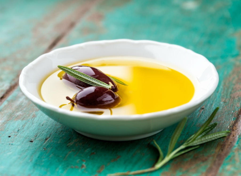 olive oil in a white bowl on a teal wood table