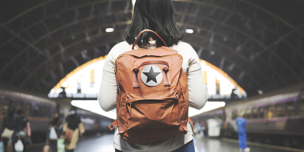 woman wears backpack on train