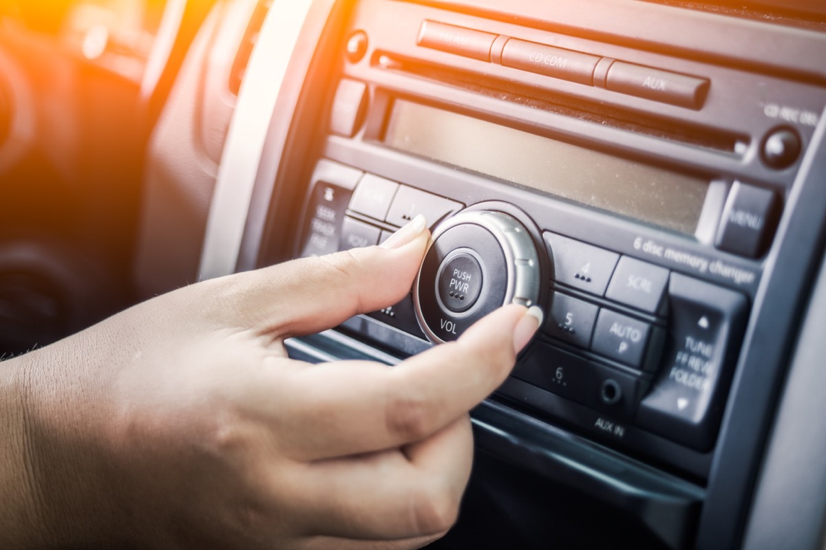 woman tuning radio in car