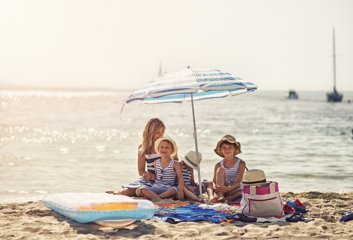 Mother wit hkids having fun on the beach. Sunny summer day. Mallorca, Spain.