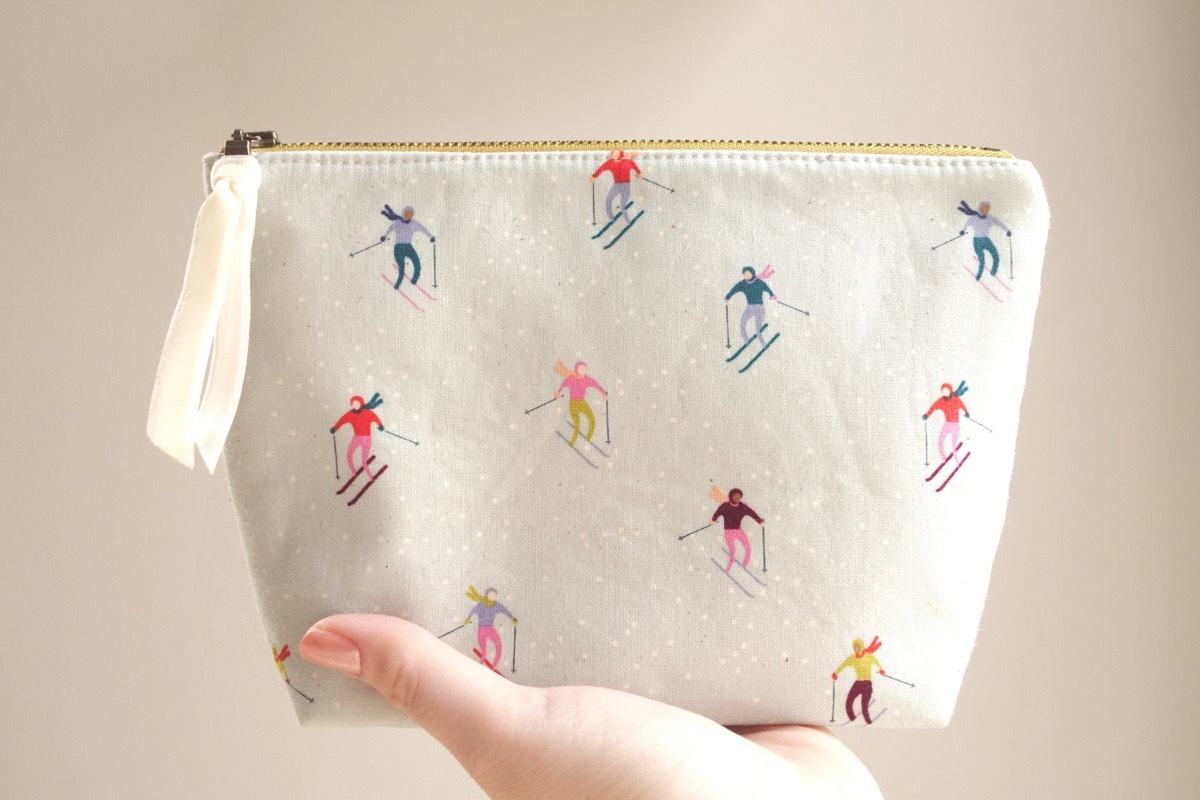 hand holding cute ski-themed makeup bag